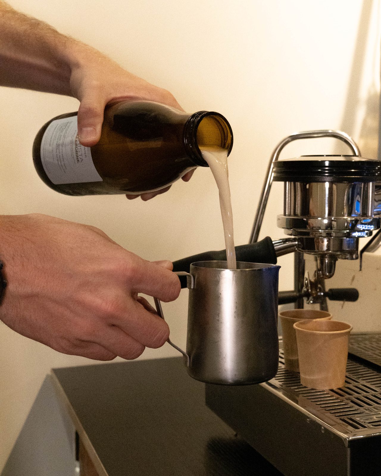 Frisch produzierter Haferdrink wird an der Kaffeebar eingeschenkt