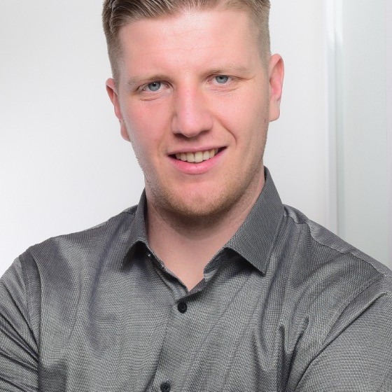 Florian Bokrant im grauen Hemd vor hellem Hintergrund