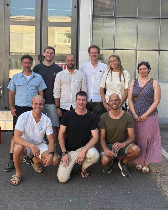 Neun Personen beim Foodhub-NRW-Netzwerktreffen stehen in zwei Reihen vor einem Gebäude im Freien