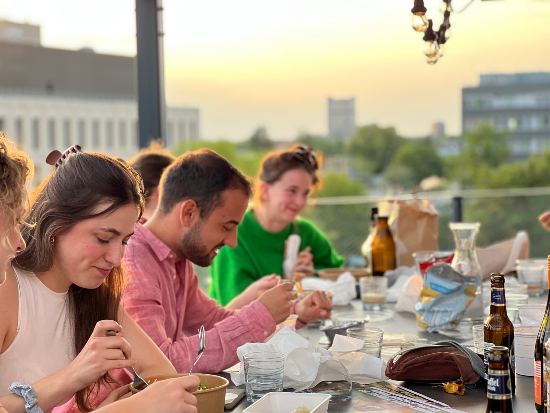 Gemeinsames Abendessen auf der Dachterrasse im Sonnenuntergang