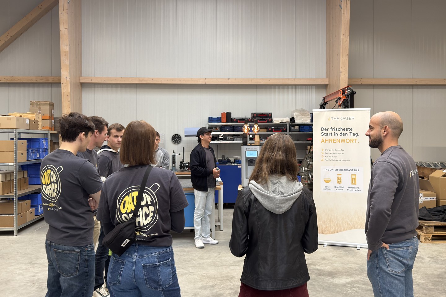 Sieben Teammitglieder hören im Workshop einer Erklärung an der The Oater Maschine zu