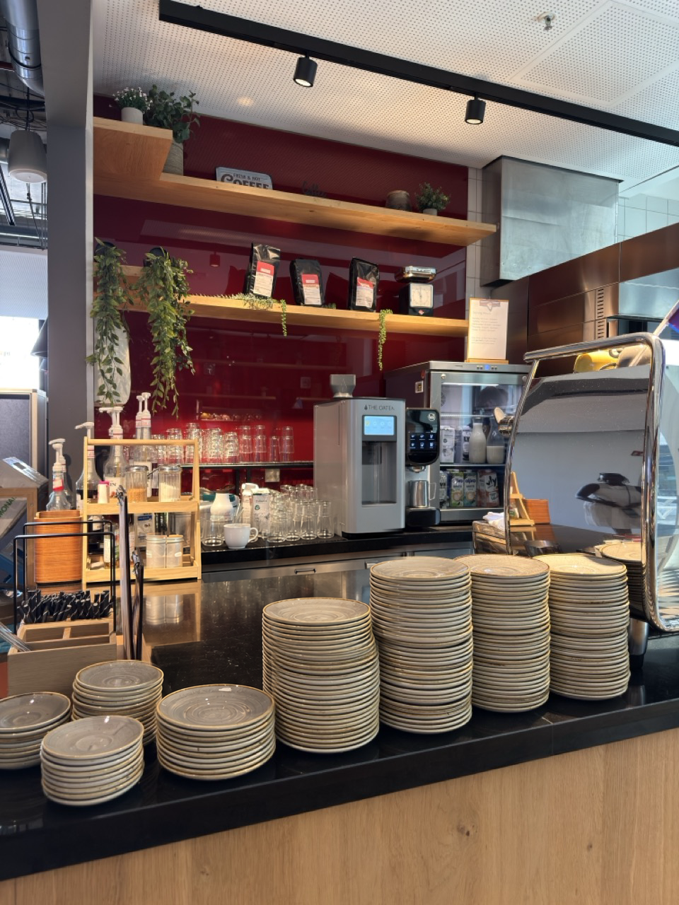 The Oater Barista im Einsatz an der Theke eines Betriebsrestaurants, umgeben von Kaffeemaschinen und Geschirr